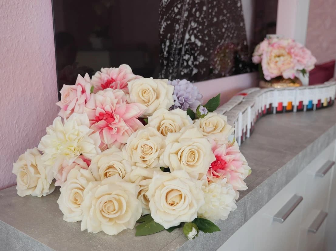 Blumen und Nagellackfarben auf der Ablage im Studio