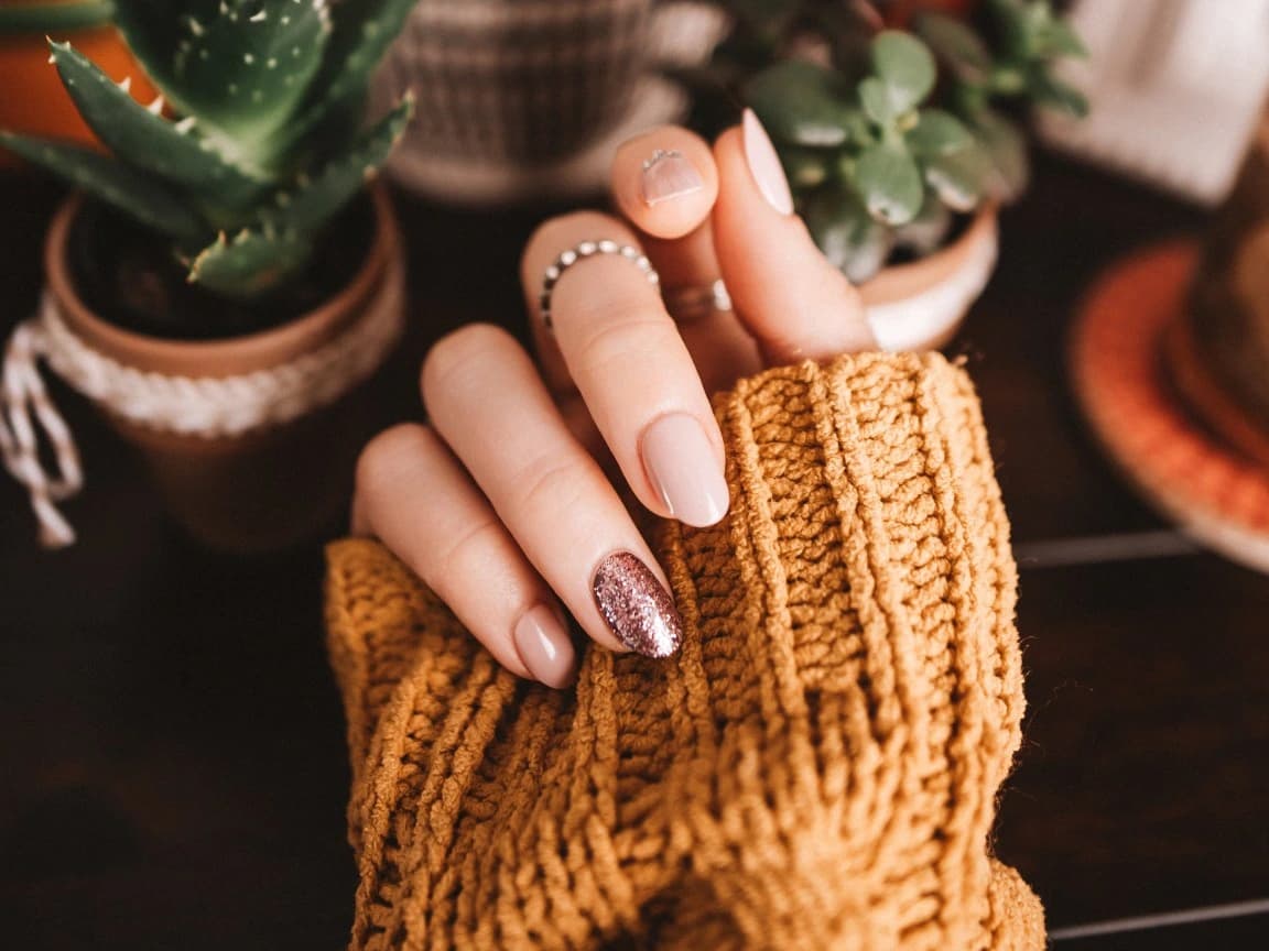Maniküre in Rosé mit einem Glitzerakzent